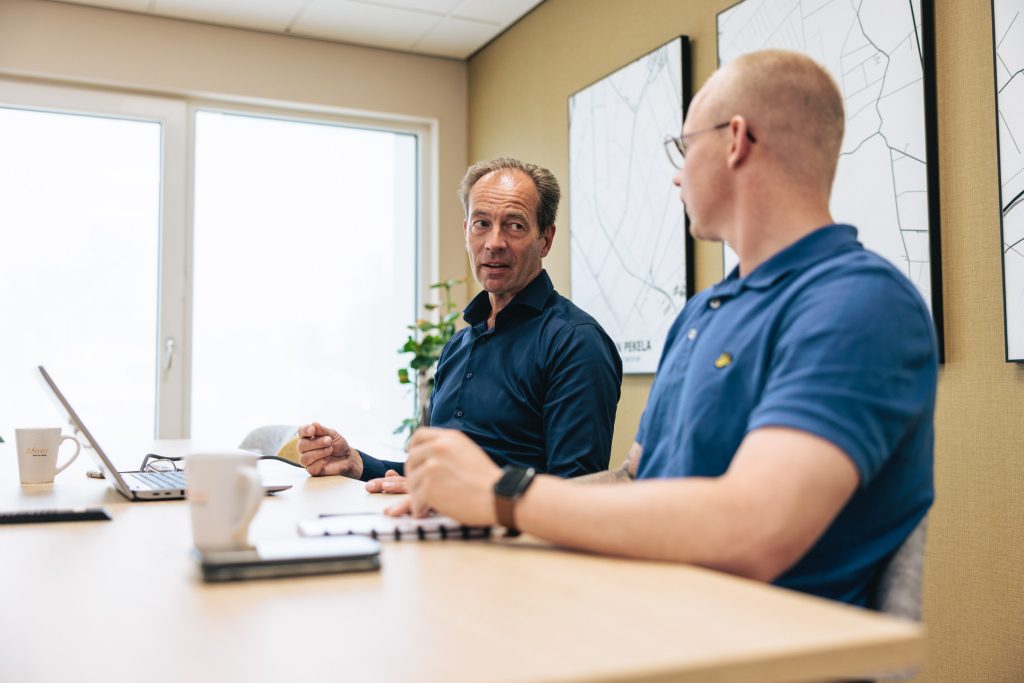 Twee mannen met elkaar in gesprek in een vergaderruimte van Afeer.