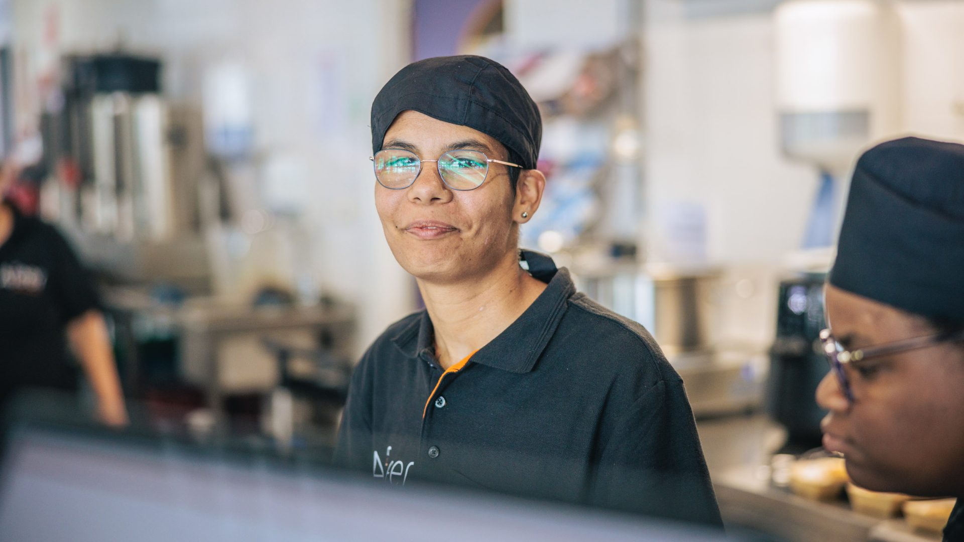 Een medewerkster van het bedrijfsrestaurant van Afeer kijkt lachend in de camera