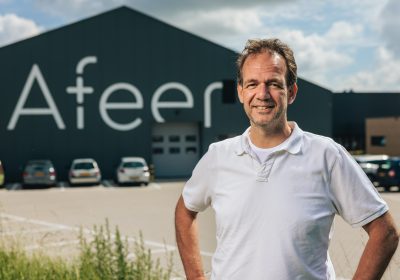 Eric Hamming buiten met logo Afeer op de achtergrond